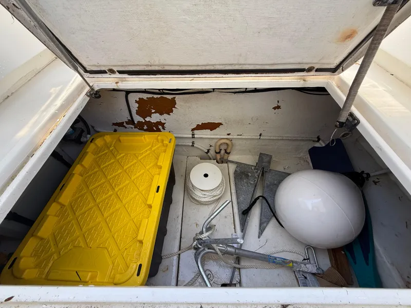 Slide: The Image of Storage compartment of 2000 Contender 35 Side Console with anchor, rope, and yellow container. - 38