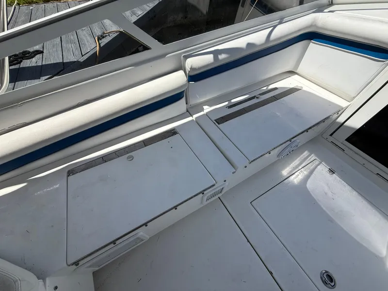 Slide: The Image of 2000 Contender 35 Side Console boat interior with white seating and storage compartments. - 39