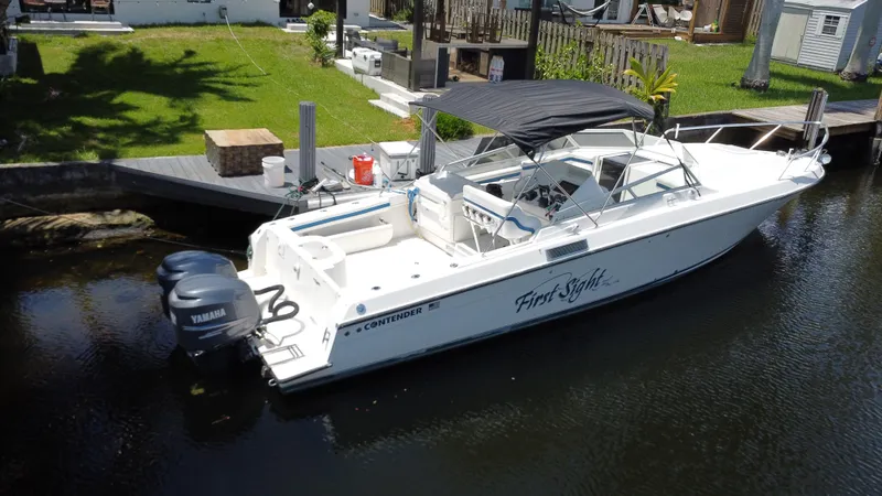 Slide: The Image of 2000 Contender 35 Side Console boat docked with dual Yamaha engines and canopy. - 4