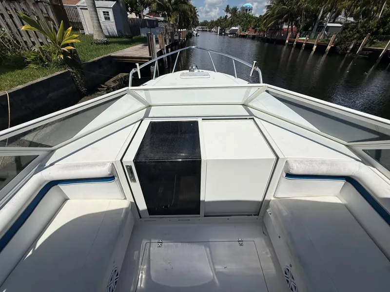 Slide: The Image of Contender 35 Side Console boat, 2000 model, docked in a canal with lush surroundings. - 42