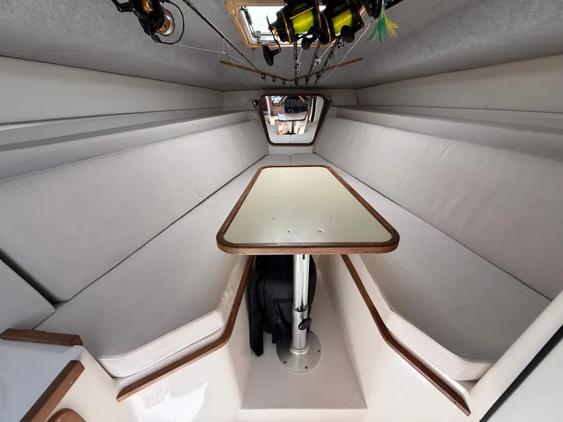 Slide: The Image of Interior of 2000 Contender 35 Side Console boat with table and fishing rods. - 46