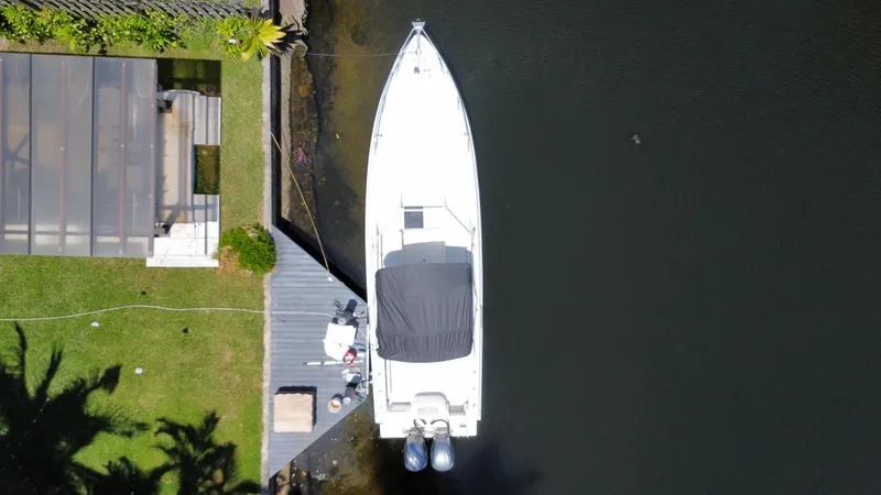 Slide: The Image of Aerial view of 2000 Contender 35 Side Console boat docked by a lakeside deck. - 6