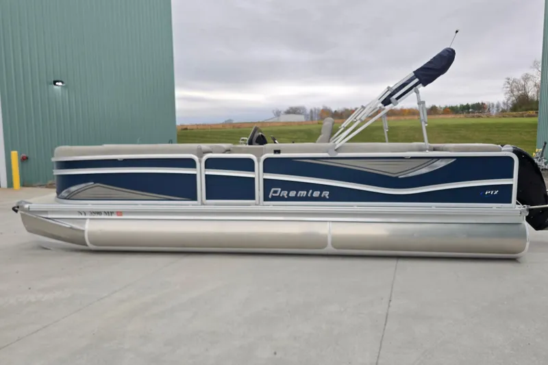 Slide: The Image of 2019 Premier 240 SunSation pontoon boat parked on concrete near a green building. - 3