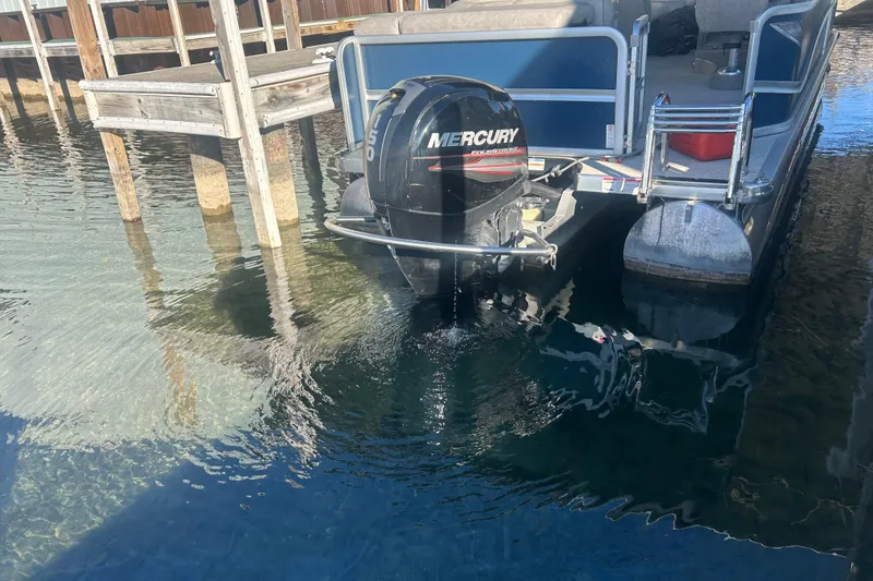 Slide: The Image of 2019 Premier 240 SunSation pontoon boat with blue and beige design, docked outdoors. - 9