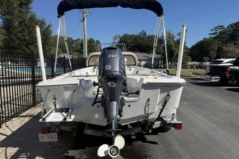Slide: The Image of 2021 Sea Pro 172 Bay boat with outboard motor on trailer, parked outdoors. - 2