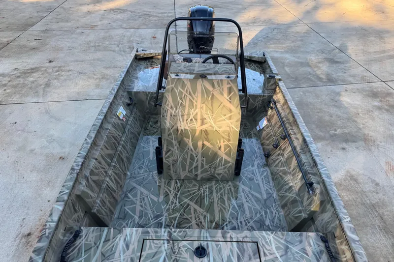 Slide: The Image of 2026 Crestliner 1860 Retriever CC boat with camouflage design on concrete surface. - 3