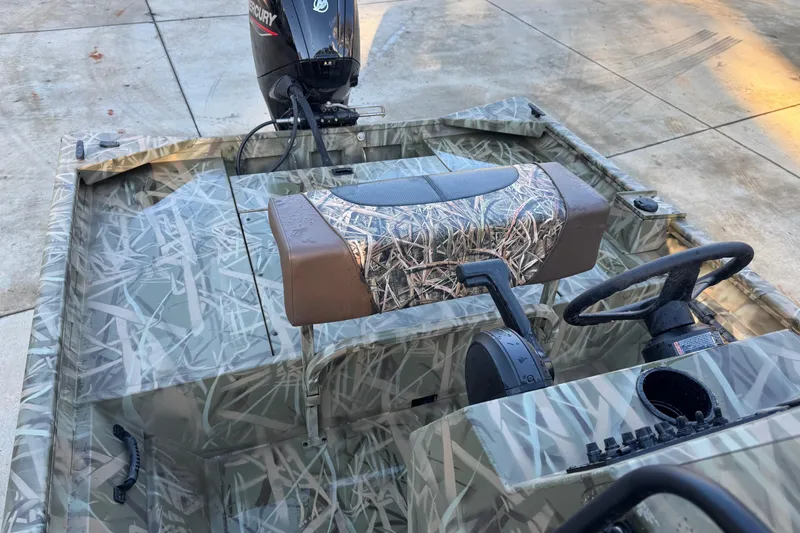 Slide: The Image of 2026 Crestliner 1860 Retriever CC boat with camouflage design and Mercury outboard motor. - 4