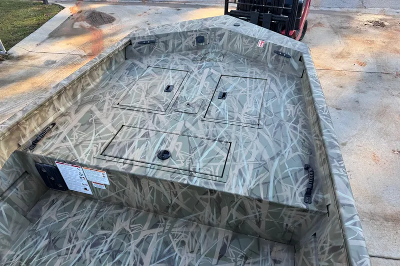 Slide: The Image of 2026 Crestliner 1860 Retriever CC boat with camouflage design on a concrete surface. - 5