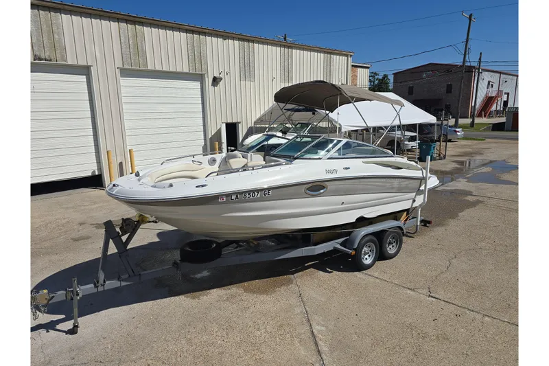 Slide: The Image of 2007 Crownline 220 LS boat on trailer, parked outside industrial building. - 11