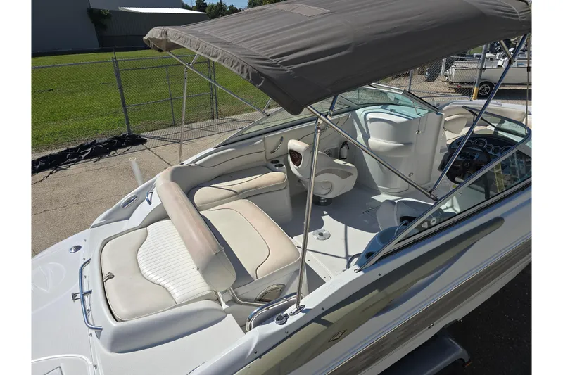 Slide: The Image of 2007 Crownline 220 LS boat interior with seating and canopy, parked outdoors. - 3