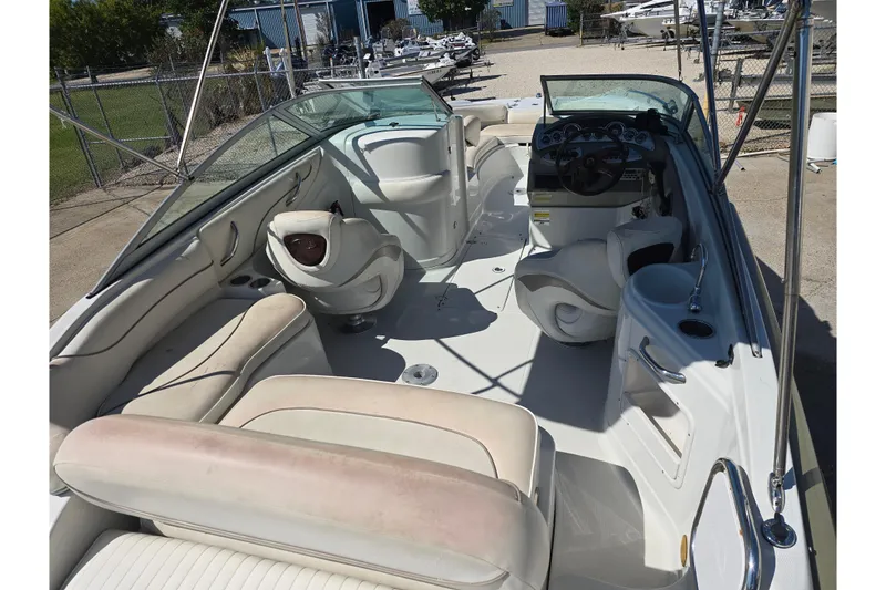 Slide: The Image of 2007 Crownline 220 LS boat interior with seating and steering wheel, docked outdoors. - 5