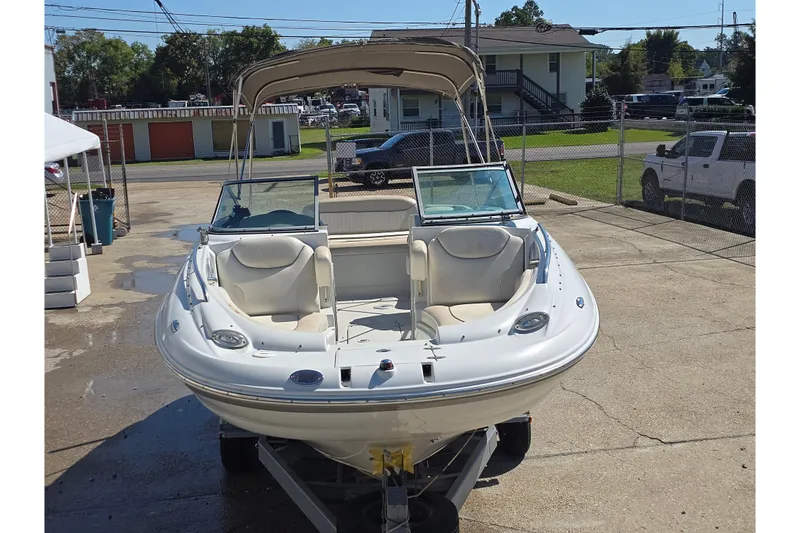 Slide: The Image of 2007 Crownline 220 LS boat with canopy, parked on a trailer in a driveway. - 7