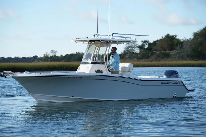 Slide: The Image of 2020 Grady-White Fisherman 236 boat on calm water, with a person at the helm. - 10