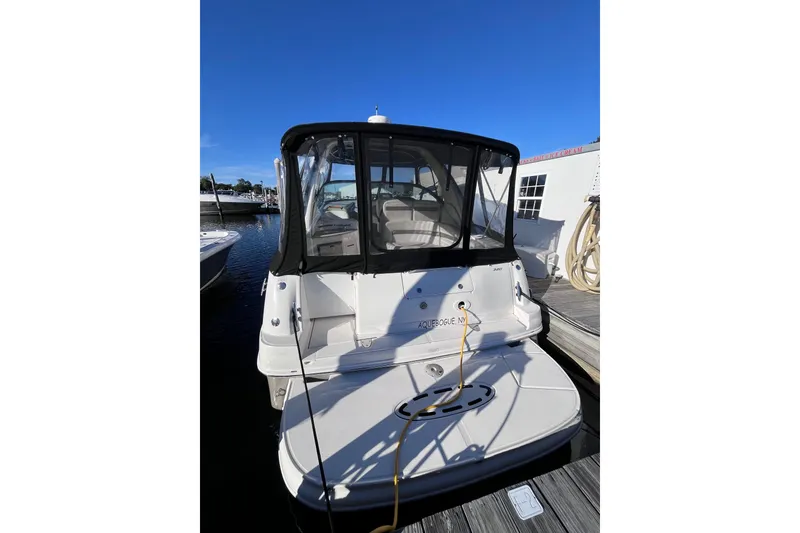 Slide: The Image of 2006 Sea Ray 320 Sundancer docked at marina, rear view with canopy. - 11
