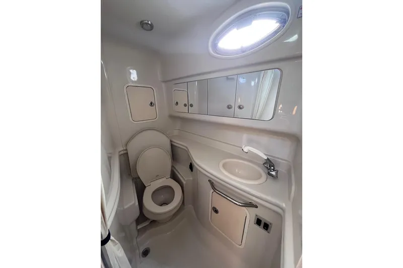 Slide: The Image of 2006 Sea Ray 320 Sundancer bathroom with toilet, sink, and storage cabinets. - 14