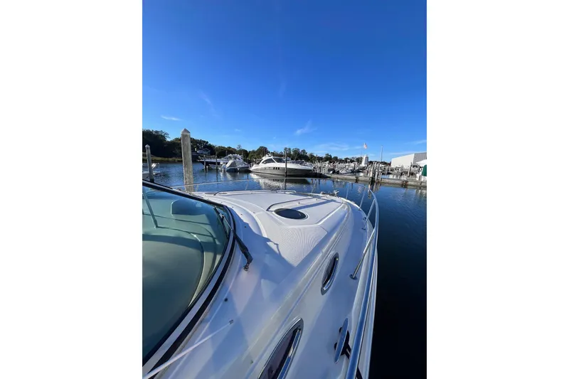 Slide: The Image of 2006 Sea Ray 320 Sundancer docked at a marina under clear blue skies. - 5