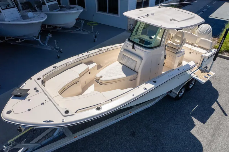 Slide: The Image of 2026 Grady-White 281 Coastal Explorer boat on trailer, showcasing sleek design and spacious deck. - 2