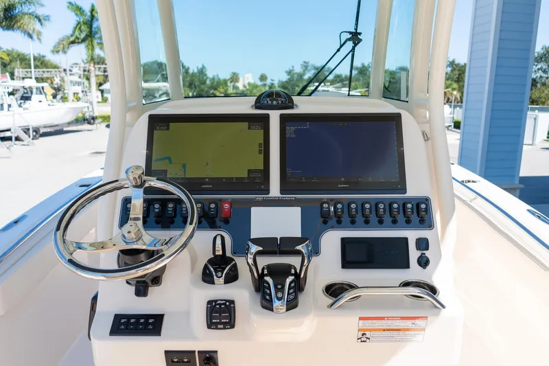 Slide: The Image of 2026 Grady-White 281 Coastal Explorer boat dashboard with dual screens and controls. - 26