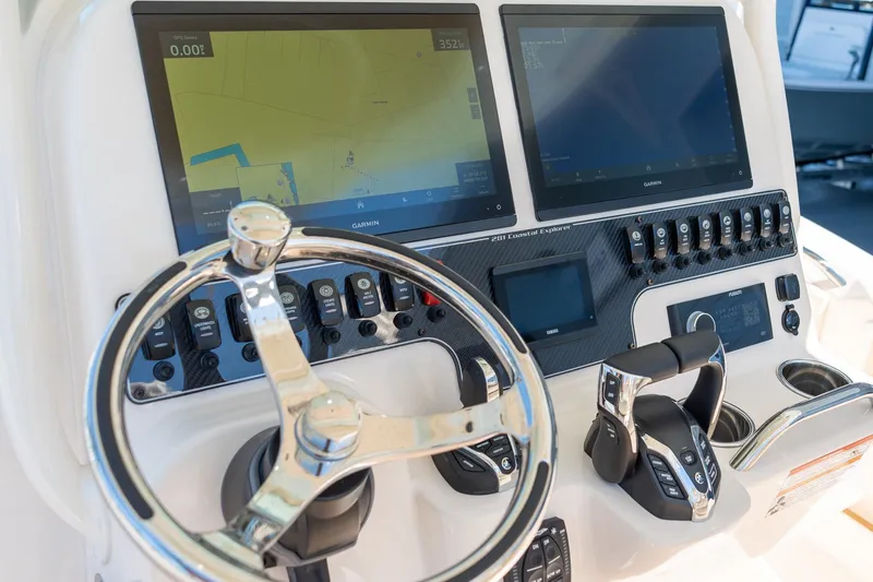 Slide: The Image of 2026 Grady-White 281 Coastal Explorer boat dashboard with dual Garmin displays and steering wheel. - 30