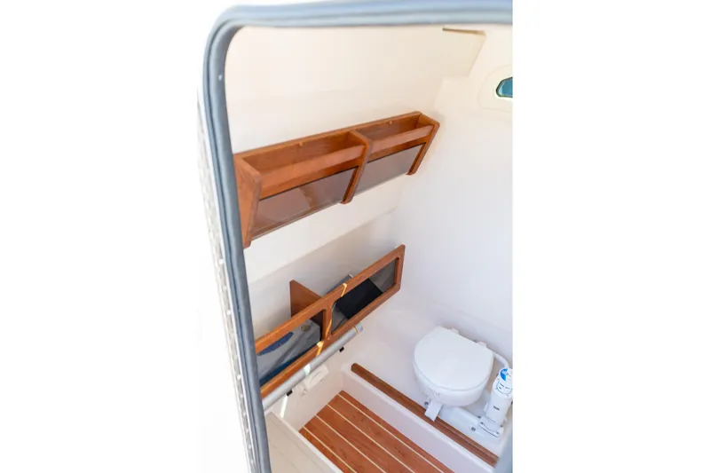 Slide: The Image of 2026 Grady-White 281 Coastal Explorer boat interior with wooden shelves and toilet. - 36