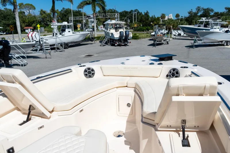 Slide: The Image of 2026 Grady-White 281 Coastal Explorer boat interior with seating and speakers in a marina. - 40