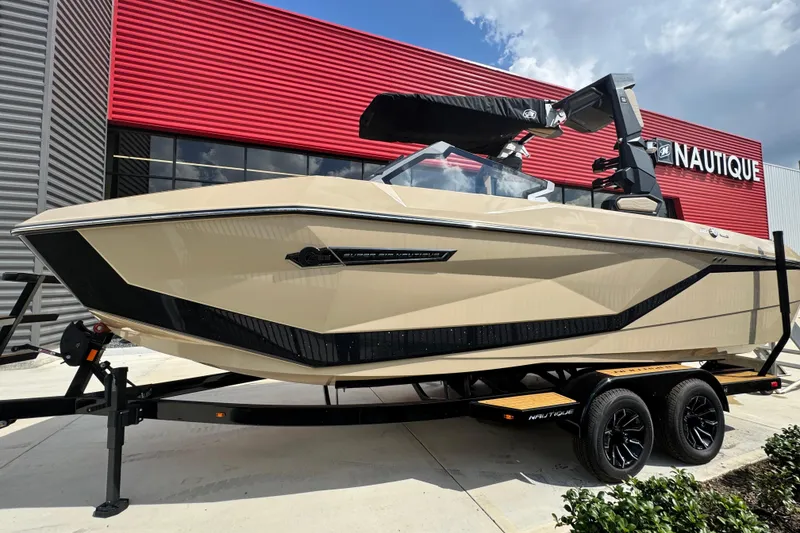 The Image of 2026 Nautique Super Air Nautique G23 Paragon boat on trailer outside dealership. - 1
