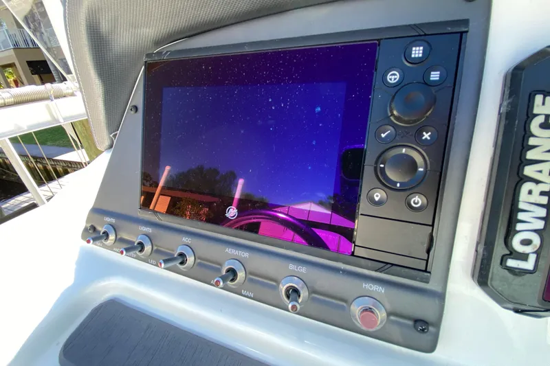 Slide: The Image of Dashboard of a 2021 Tahoe 2150 CC boat with Lowrance display and control switches. - 10