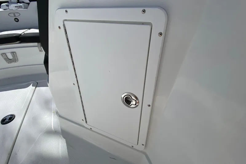 Slide: The Image of 2021 Tahoe 2150 CC boat storage compartment with latch, interior view. - 17