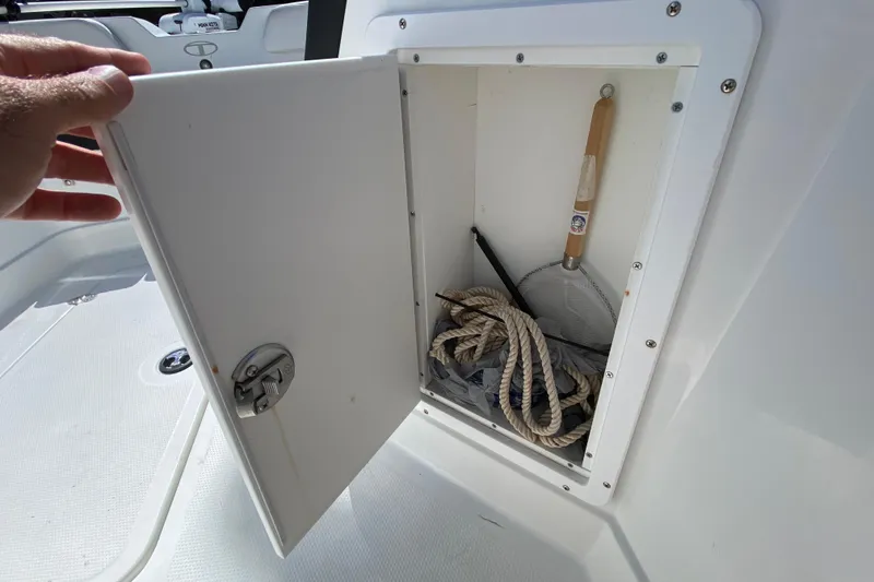 Slide: The Image of Open storage compartment on 2021 Tahoe 2150 CC boat with rope and net inside. - 18