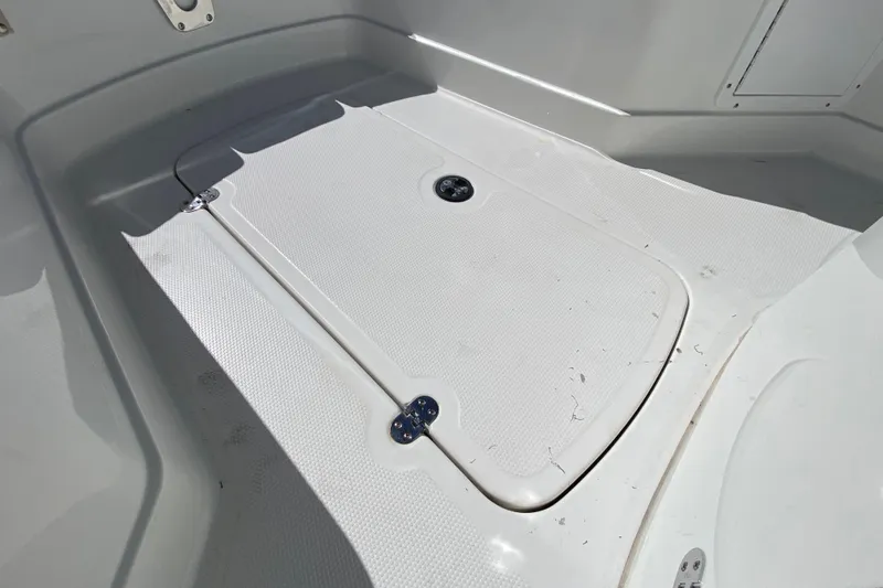 Slide: The Image of 2021 Tahoe 2150 CC boat deck with storage compartment, white textured surface. - 21