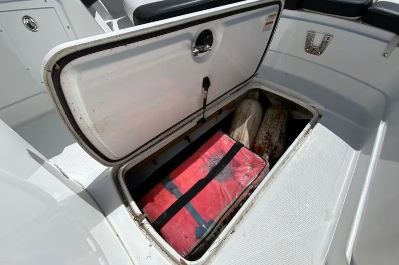 Slide: The Image of Open storage compartment on 2021 Tahoe 2150 CC boat with red bag and fenders. - 22
