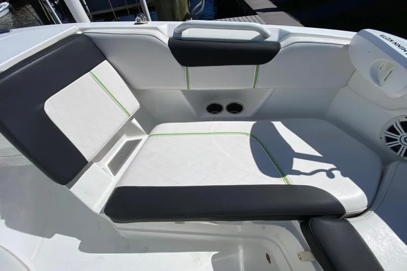 Slide: The Image of 2021 Tahoe 2150 CC boat seating area with white and black upholstery, green accents. - 27