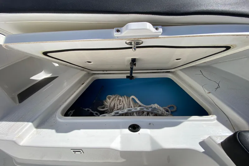 Slide: The Image of Open storage compartment on 2021 Tahoe 2150 CC boat with rope and chain inside. - 28