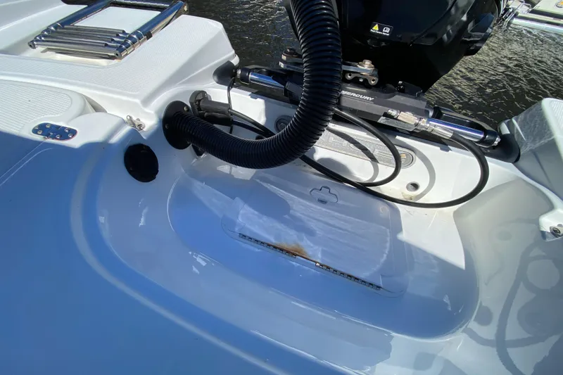 Slide: The Image of 2021 Tahoe 2150 CC boat engine area with visible cables and ladder. - 44