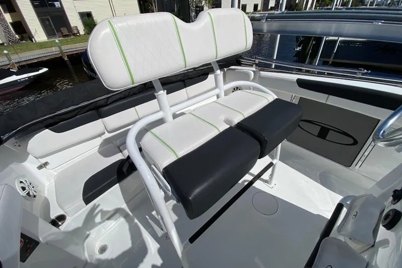 Slide: The Image of 2021 Tahoe 2150 CC boat interior with white and green seating, docked by water. - 49
