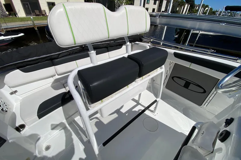 Slide: The Image of 2021 Tahoe 2150 CC boat interior with white and black seating, docked by the water. - 5