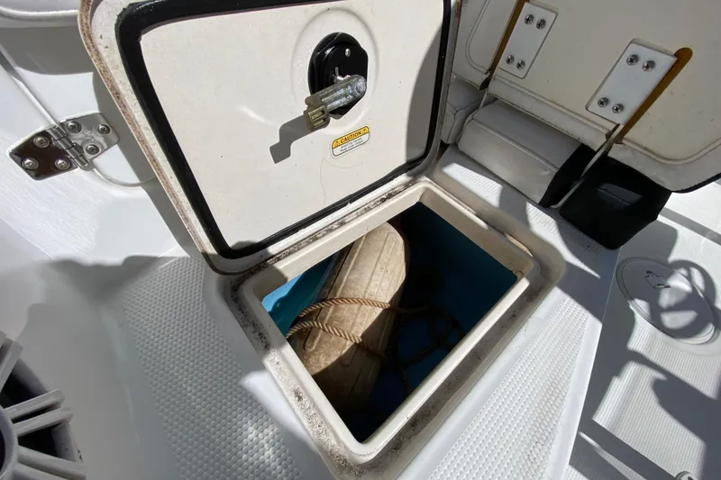 Slide: The Image of Open storage compartment on 2021 Tahoe 2150 CC boat, showing interior and rope. - 52