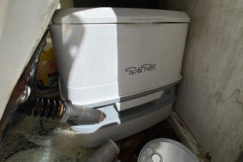Slide: The Image of Portable toilet in a 2021 Tahoe 2150 CC boat storage compartment. - 58
