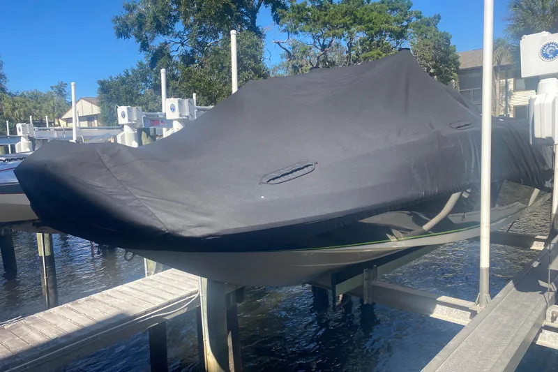 Slide: The Image of 2021 Tahoe 2150 CC boat covered and docked on a lift. - 60