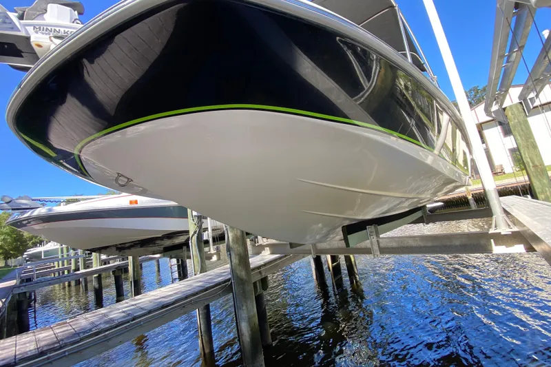 Slide: The Image of 2021 Tahoe 2150 CC boat on lift, docked by waterfront. - 66