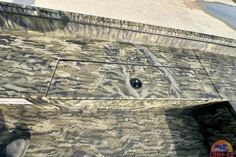 Slide: The Image of 2026 SeaArk 1752 Slayer X Pro boat with camouflage design and storage compartment. - 15