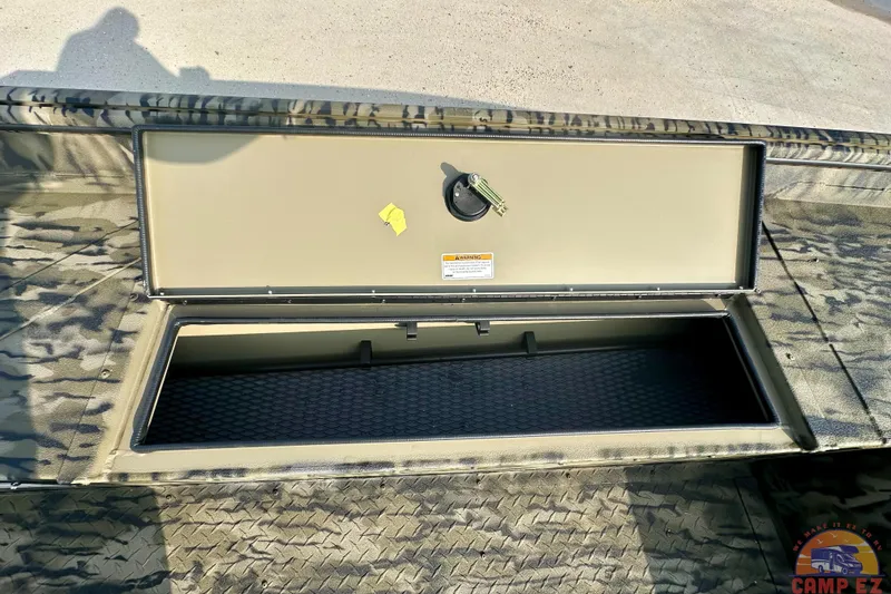 Slide: The Image of Open storage compartment of 2026 SeaArk 1752 Slayer X Pro boat, featuring camouflage design. - 16