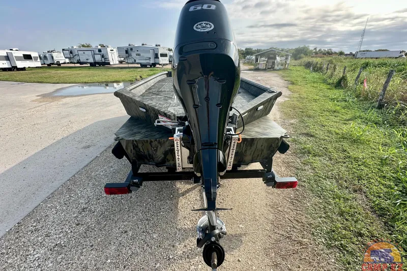 Slide: The Image of 2026 SeaArk 1752 Slayer X Pro boat with outboard motor, parked outdoors. - 3