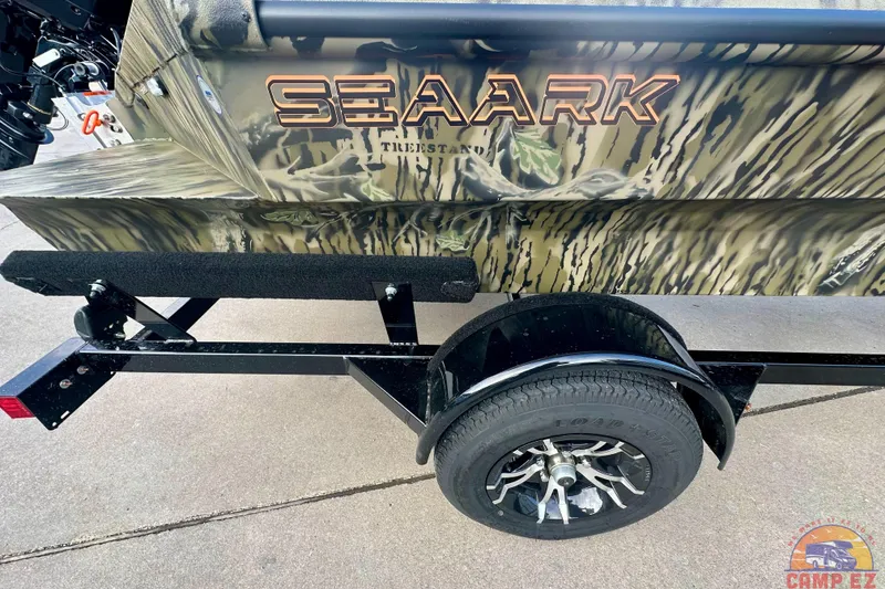 Slide: The Image of 2026 SeaArk 1752 Slayer X Pro boat with camouflage design on a trailer. - 7