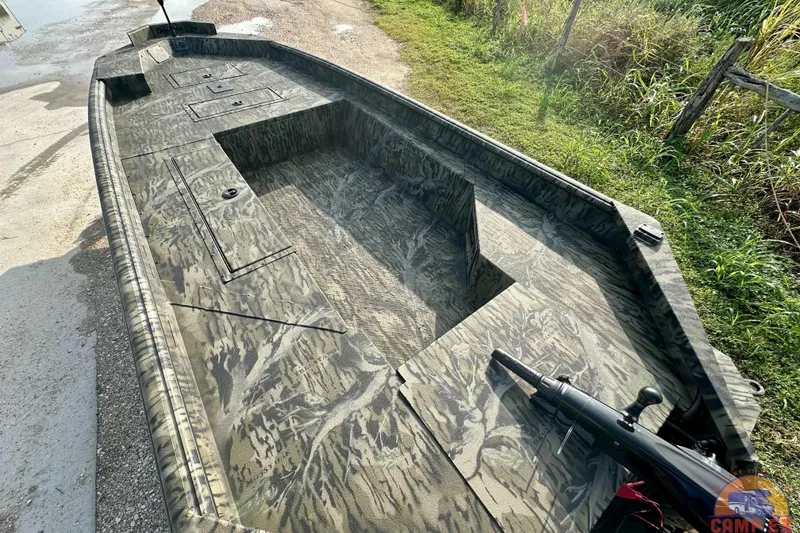 Slide: The Image of 2026 SeaArk 1752 Slayer X Pro boat with camouflage design, parked on a grassy area. - 8