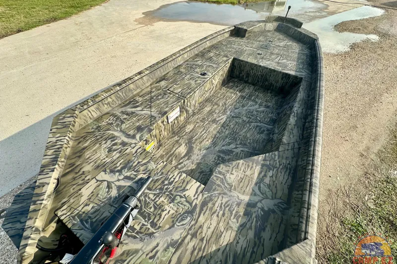 Slide: The Image of 2026 SeaArk 1752 Slayer X Pro boat with camouflage design on a concrete surface. - 9