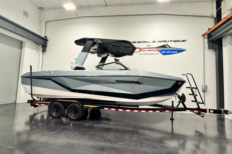 The Image of 2026 Nautique Super Air Nautique G23 Paragon boat on trailer in showroom. - 1