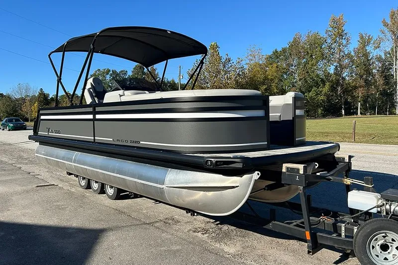 Slide: The Image of 2025 Viaggio Z22D pontoon boat on trailer, parked outdoors under clear blue sky. - 4