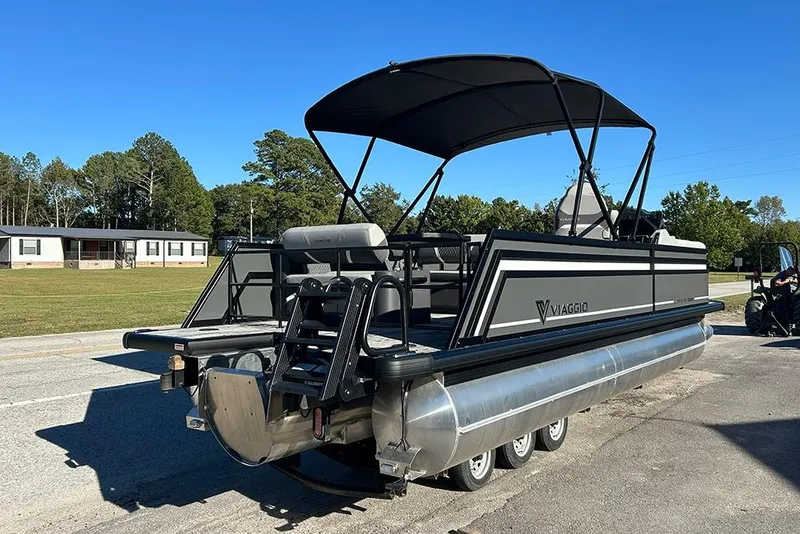 Slide: The Image of 2025 Viaggio Z22D pontoon boat with canopy, parked on a sunny day. - 5