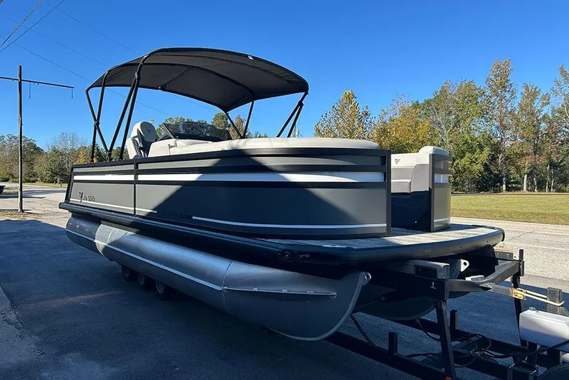 Slide: The Image of 2025 Viaggio Z22D pontoon boat on trailer, parked outdoors under clear blue sky. - 8